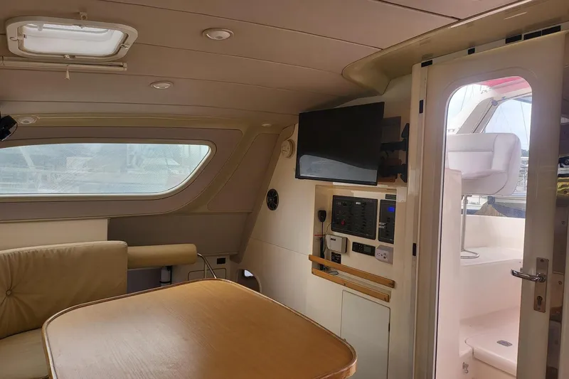 Slide: The Image of Covered helm station on a 2000 Leopard 38 catamaran, featuring stainless steel wheel. - 32