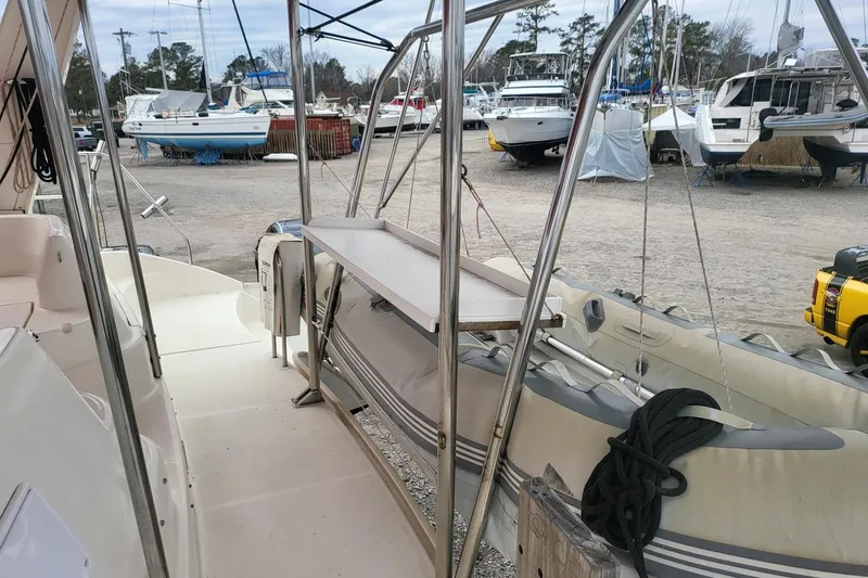 Slide: The Image of Helm station of 2000 Leopard 38 catamaran with white seating and marina view. - 41