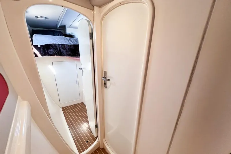 Slide: The Image of Interior of a 2000 Leopard 38 yacht showing a cozy cabin with a bed and wooden flooring. - 57