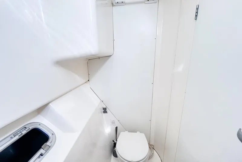 Slide: The Image of Compact bathroom in a 2000 Leopard 38 yacht, featuring a toilet and small window. - 64
