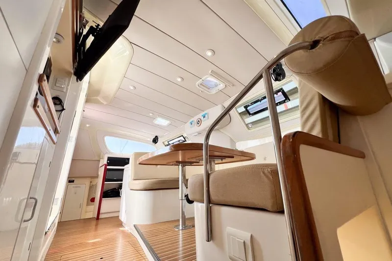 Slide: The Image of Interior of a 2000 Leopard 38 catamaran, featuring modern seating and wooden accents. - 84