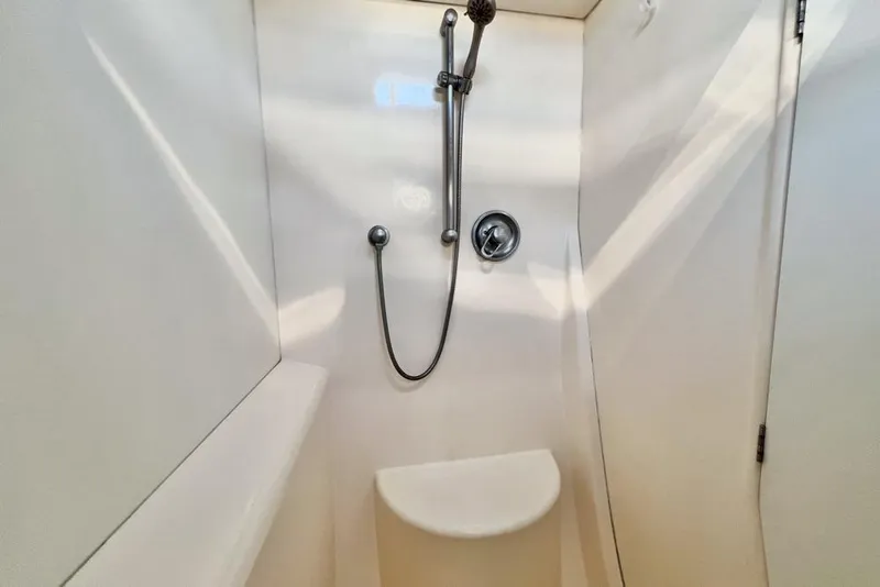 Slide: The Image of Compact shower area in a 2000 Leopard 38 yacht, featuring a handheld showerhead. - 90
