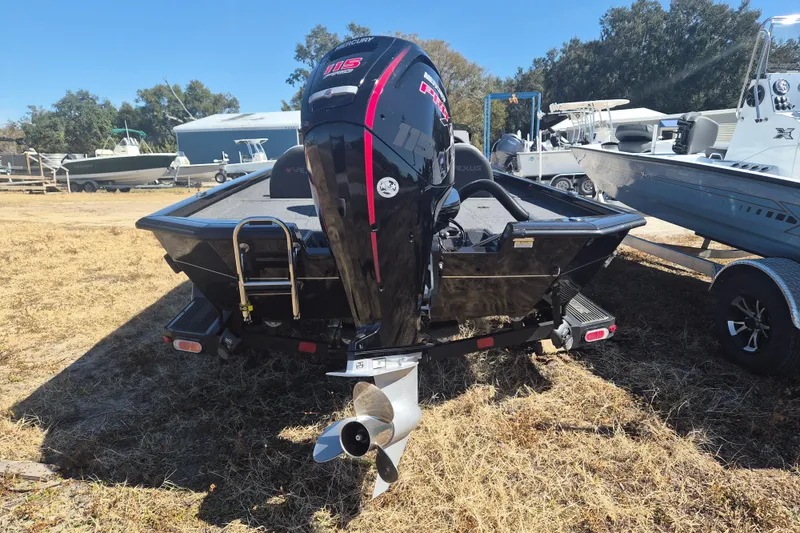 Slide: The Image of 2023 Vexus AVX1880 boat with Mercury 115 engine, parked on dry grass. - 3