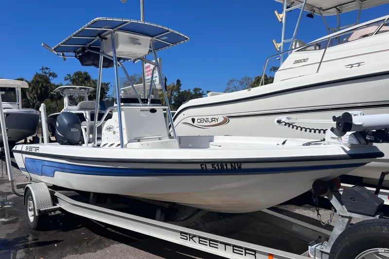 Slide: The Image of 2008 Skeeter ZX20 Bay boat on trailer, parked beside other boats. - 5