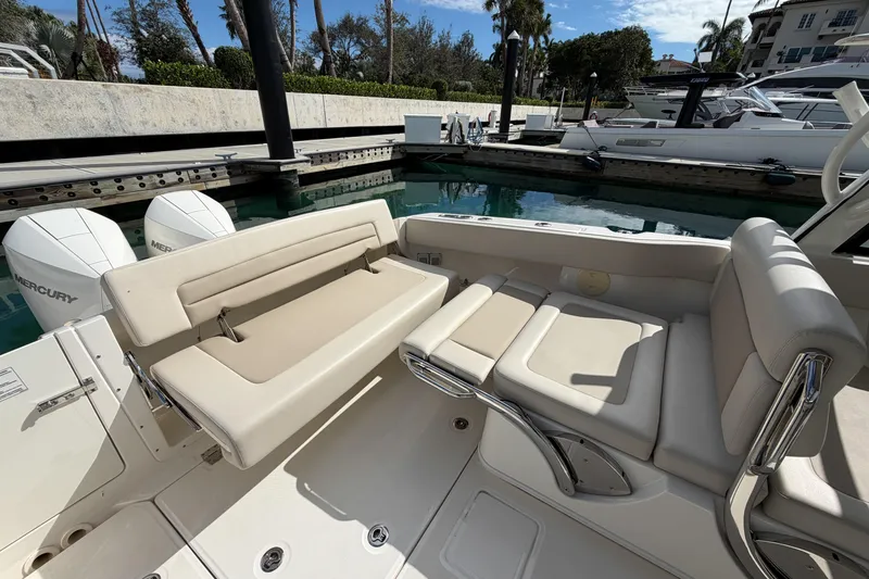Slide: The Image of 2022 Boston Whaler 320 Vantage boat interior with seating and Mercury engines at dock. - 12