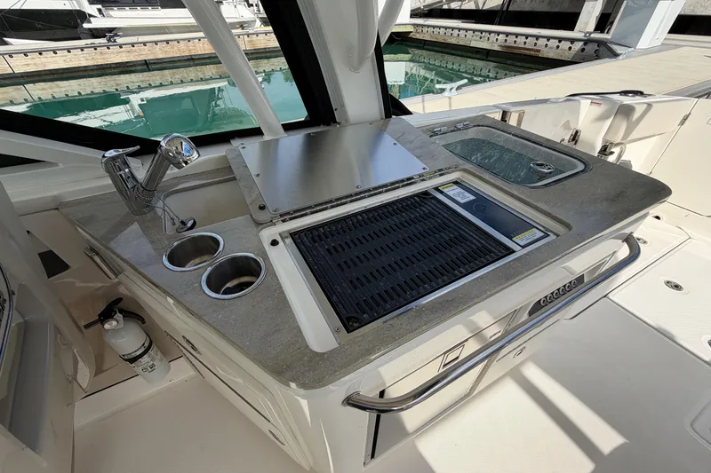 Slide: The Image of 2022 Boston Whaler 320 Vantage boat kitchen area with grill and sink. - 21