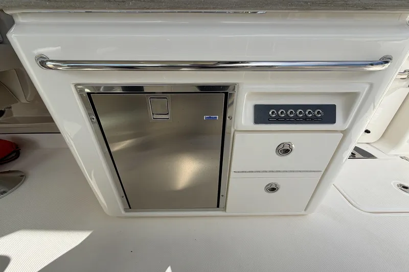 Slide: The Image of 2022 Boston Whaler 320 Vantage boat interior with control panel and storage compartments. - 22