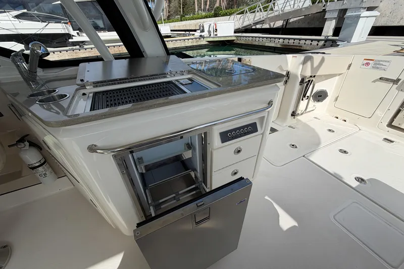 Slide: The Image of 2022 Boston Whaler 320 Vantage boat interior with grill and storage compartments. - 23