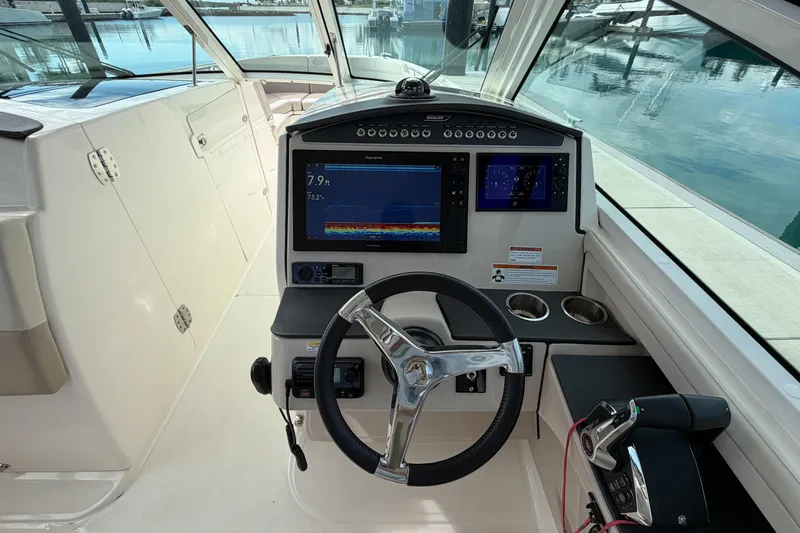 Slide: The Image of 2022 Boston Whaler 320 Vantage helm with modern navigation displays and steering wheel. - 28