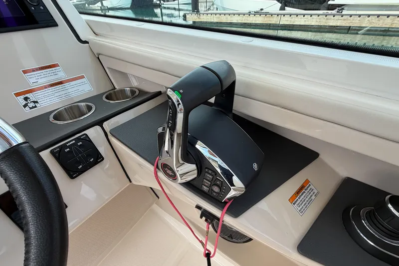 Slide: The Image of Control panel of 2022 Boston Whaler 320 Vantage boat with throttle and cup holders. - 31