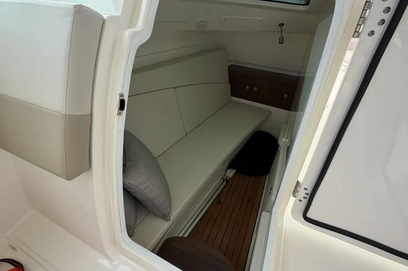 Slide: The Image of Interior cabin of 2022 Boston Whaler 320 Vantage with cushioned seating and wooden flooring. - 34