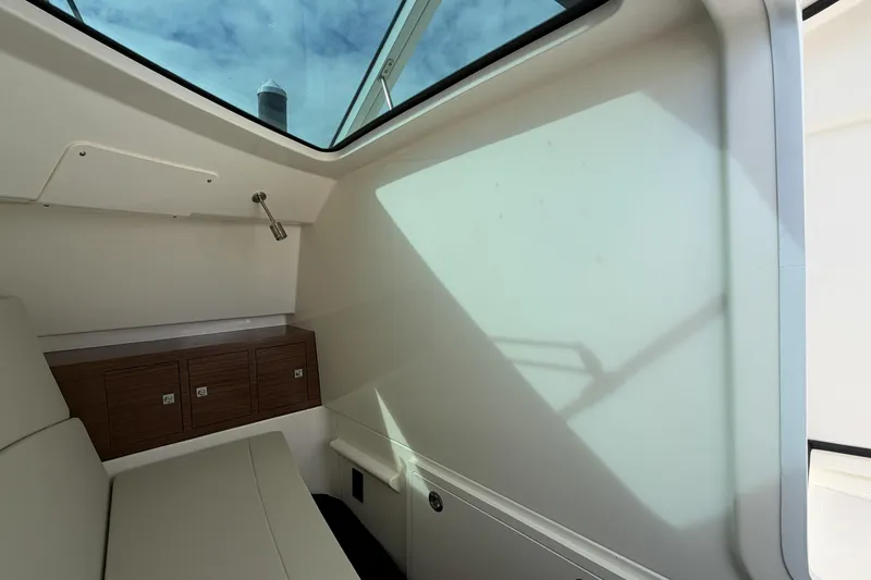 Slide: The Image of Interior cabin of 2022 Boston Whaler 320 Vantage with skylight and wooden storage. - 35