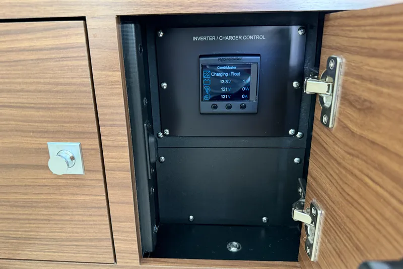 Slide: The Image of Inverter charger control panel inside 2022 Boston Whaler 320 Vantage cabinet. - 37