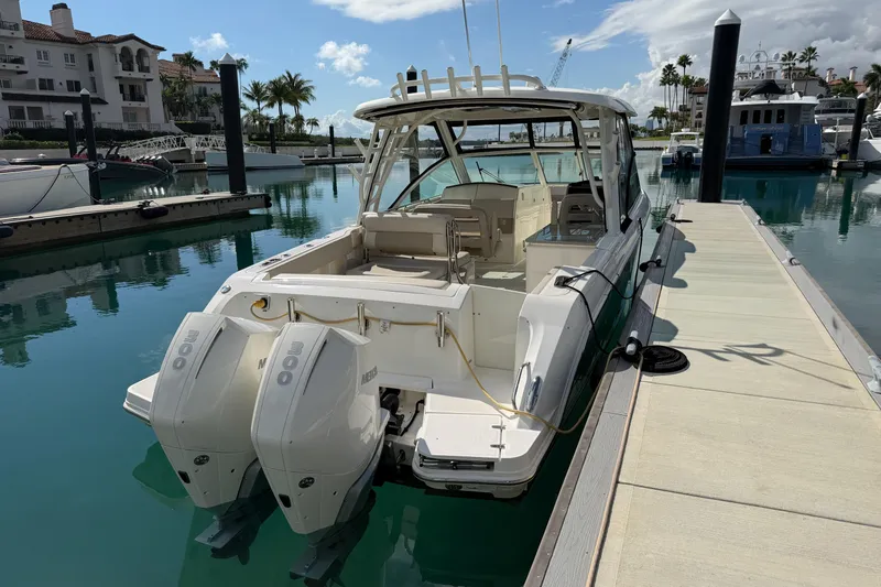 Slide: The Image of 2022 Boston Whaler 320 Vantage docked at marina with twin engines. - 4