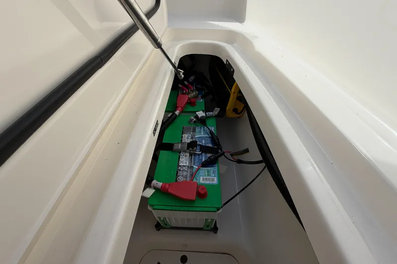 Slide: The Image of 2022 Boston Whaler 320 Vantage battery compartment with green marine battery. - 41