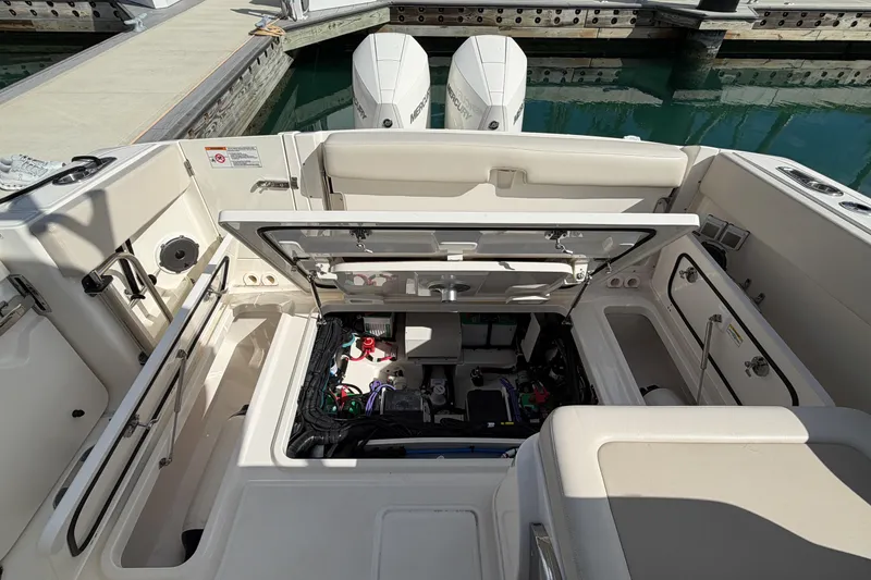 Slide: The Image of 2022 Boston Whaler 320 Vantage boat interior with open engine compartment at dock. - 45
