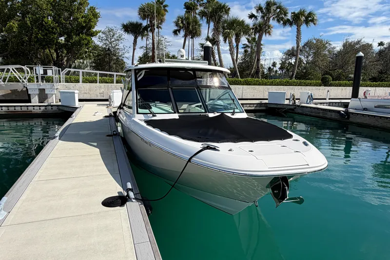 Slide: The Image of 2022 Boston Whaler 320 Vantage docked in a marina with palm trees. - 52