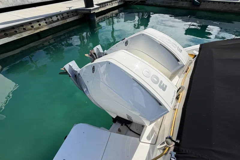 Slide: The Image of 2022 Boston Whaler 320 Vantage with twin Mercury outboard engines docked in clear water. - 53