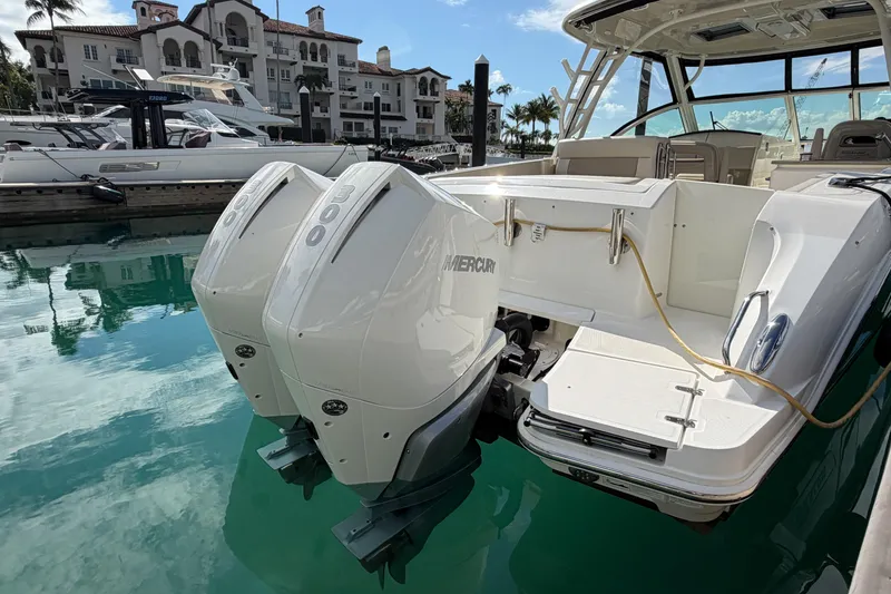 Slide: The Image of 2022 Boston Whaler 320 Vantage with twin Mercury outboard engines docked in marina. - 6