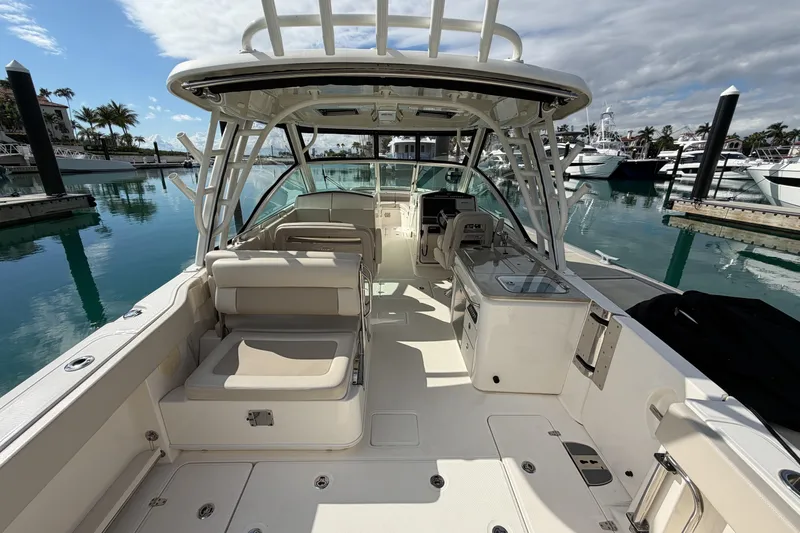 Slide: The Image of 2022 Boston Whaler 320 Vantage boat interior at marina, showcasing seating and helm. - 9
