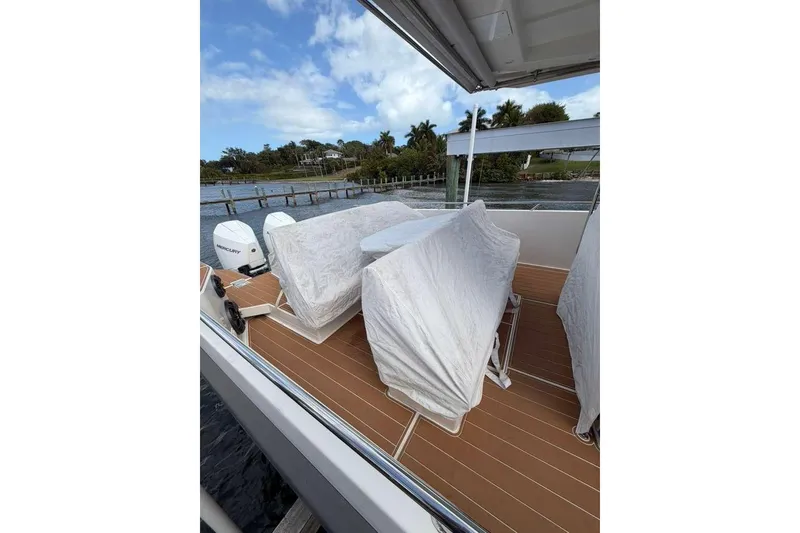 Slide: The Image of 2021 Nimbus T11 boat deck with covered seating and twin Mercury engines. - 18
