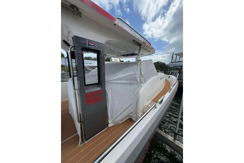 Slide: The Image of Nimbus T11 2021 boat docked, featuring sleek design and covered seating area. - 19