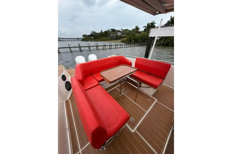 Slide: The Image of Red seating area on 2021 Nimbus T-11 boat with wooden table, dockside view. - 5