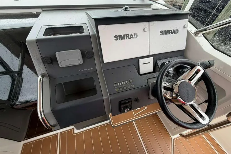 Slide: The Image of 2021 Nimbus T-11 boat dashboard with Simrad displays and steering wheel. - 9