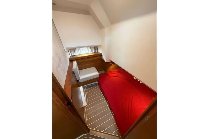 Slide: The Image of 2021 Nimbus T-11 cabin interior with red bedding and wooden accents. - 12