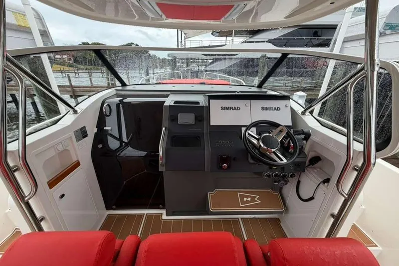 Slide: The Image of 2021 Nimbus T-11 boat dashboard with Simrad displays and steering wheel. - 8