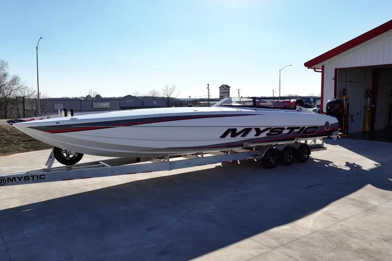 Slide: The Image of 2019 Mystic Powerboats C3800 on trailer outside a garage in daylight. - 11
