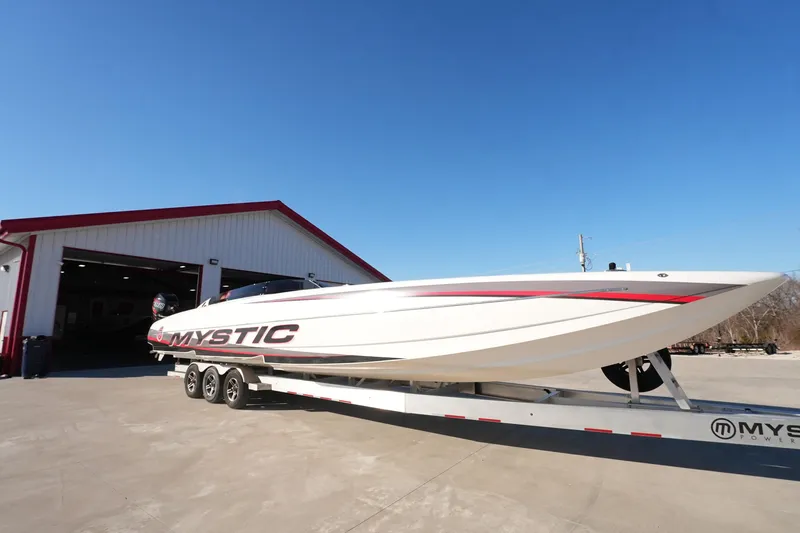 Slide: The Image of 2019 Mystic Powerboats C3800 on trailer outside a garage under clear blue sky. - 22