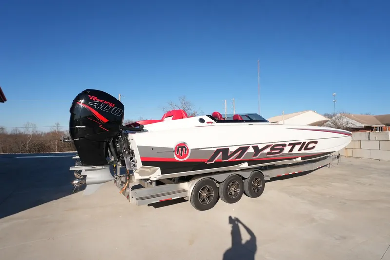 Slide: The Image of 2019 Mystic Powerboats C3800 on trailer, featuring powerful outboard engine, clear blue sky backdrop. - 24