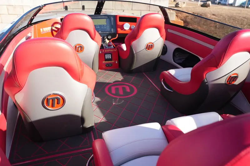 Slide: The Image of 2019 Mystic Powerboats C3800 interior with red and gray seating, modern dashboard, and logo accents. - 35