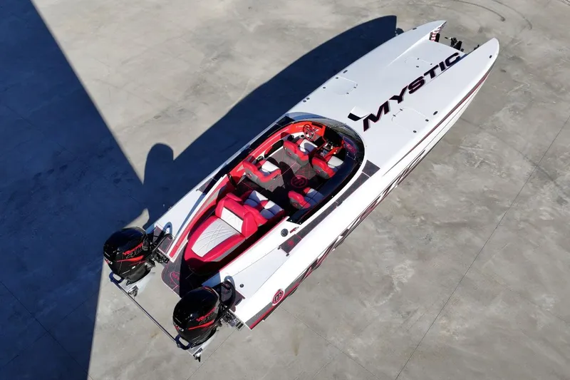Slide: The Image of 2019 Mystic Powerboats C3800, sleek design with red and white interior, aerial view. - 8