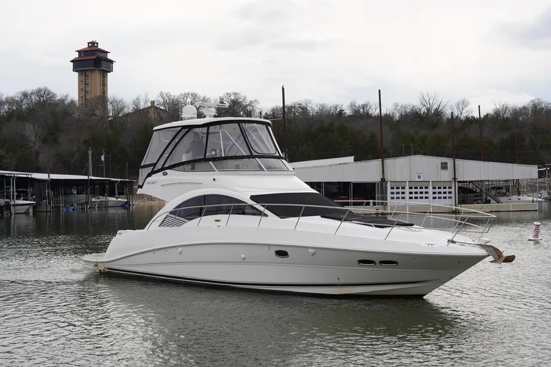 Slide: The Image of 2009 Sea Ray 47 Sedan Bridge yacht docked in a marina with a tower in the background. - 11
