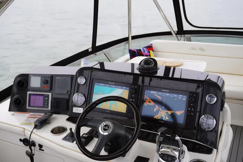 Slide: The Image of 2009 Sea Ray 47 Sedan Bridge helm with navigation screens and controls. - 13