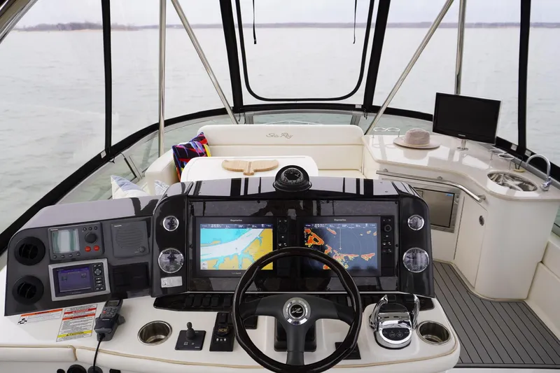 Slide: The Image of 2009 Sea Ray 47 Sedan Bridge helm with navigation screens and luxurious seating. - 14