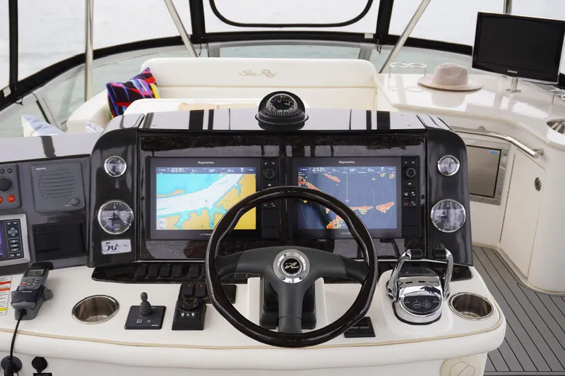 Slide: The Image of 2009 Sea Ray 47 Sedan Bridge helm with navigation screens and controls. - 18