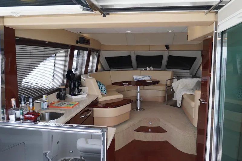 Slide: The Image of Luxurious interior of 2009 Sea Ray 47 Sedan Bridge yacht with elegant seating and kitchenette. - 30