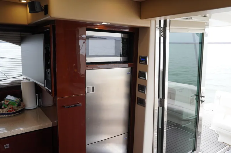 Slide: The Image of 2009 Sea Ray 47 Sedan Bridge yacht interior with kitchen appliances and ocean view. - 34