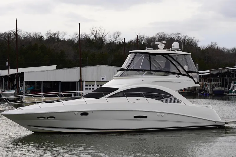 Slide: The Image of 2009 Sea Ray 47 Sedan Bridge yacht docked at a marina, overcast sky. - 5