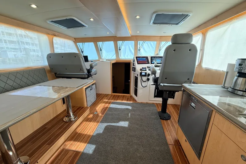 Slide: The Image of Control panel of a 2025 Wesmac 42 boat with multiple switches on a wooden surface. - 16