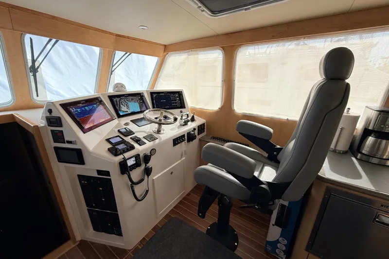 Slide: The Image of Pilothouse interior of 2025 Wesmac 42 boat, featuring helm station and kitchenette. - 24