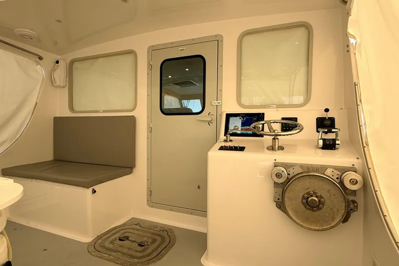 Slide: The Image of Helm of 2025 Wesmac 42 boat with steering wheel, navigation display, and controls. - 61