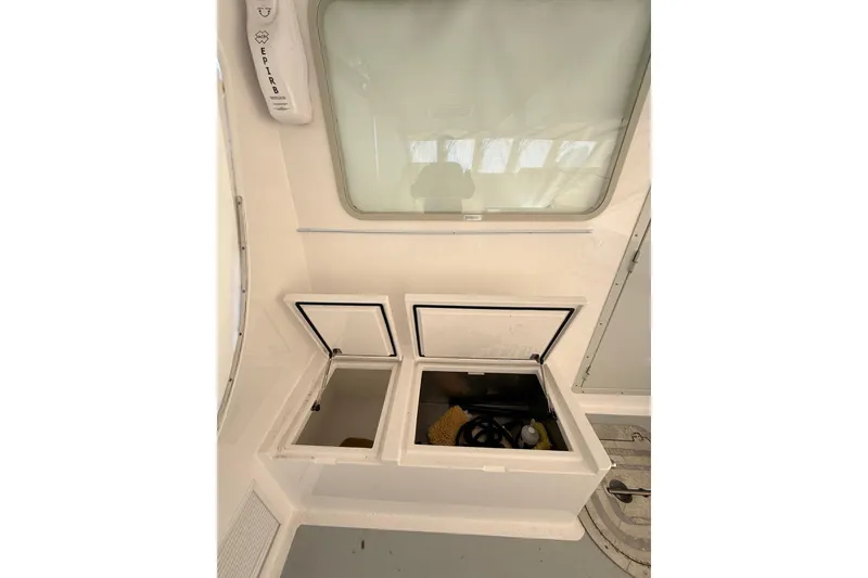 Slide: The Image of Interior of 2025 Wesmac 42 boat, featuring helm controls and storage compartment. - 63