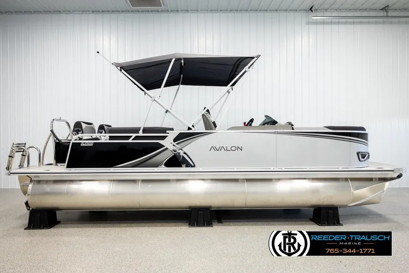 Slide: The Image of 2026 Avalon LSZ QLS pontoon boat with canopy in showroom, Reeder-Trausch Marine logo visible. - 5