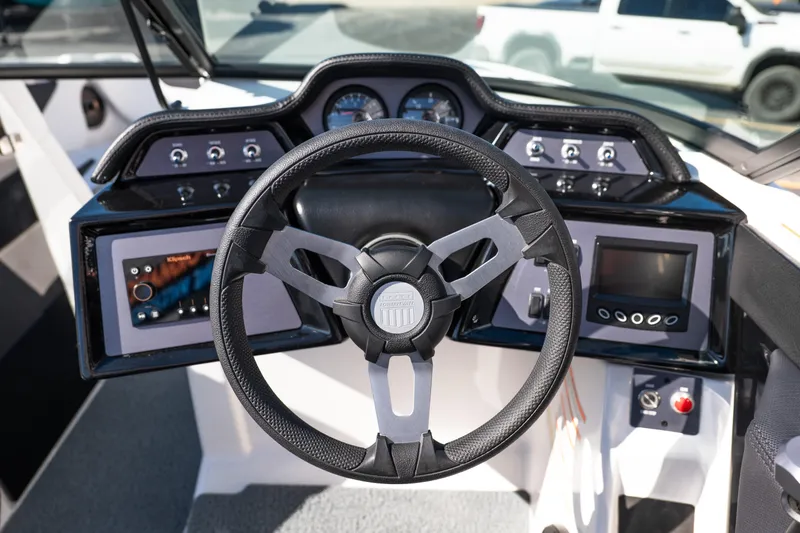 Slide: The Image of 2023 MasterCraft NXT22 boat dashboard with steering wheel and control panel. - 13