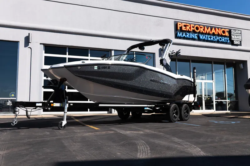 The Image of 2023 MasterCraft NXT22 boat on trailer outside Performance Marine Watersports dealership. - 2