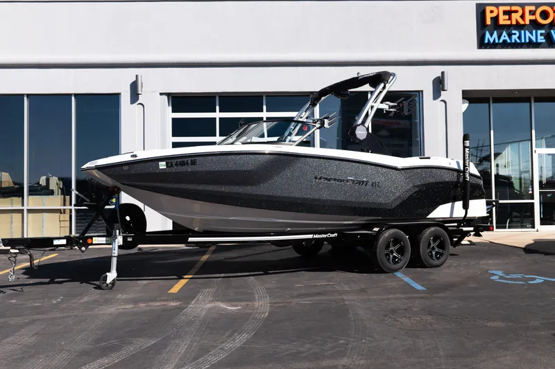 Slide: The Image of 2023 MasterCraft NXT22 boat on trailer outside marine dealership. - 3